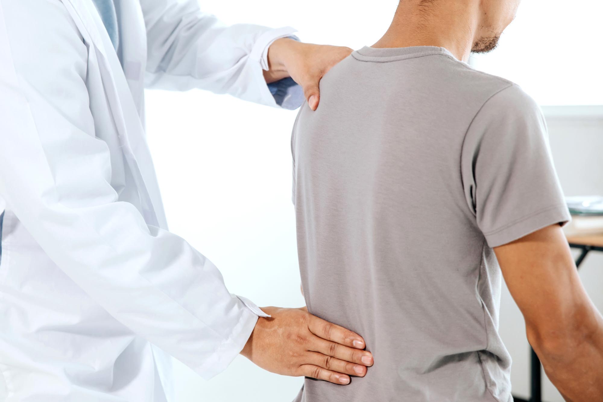 Physiotherapist doing healing treatment on man’s back.Back pain
